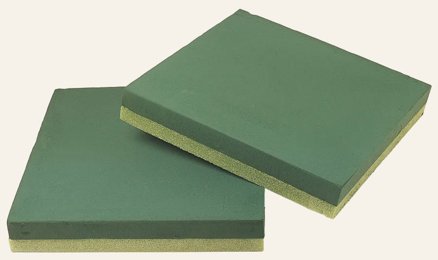 Two green foam pads on a white background