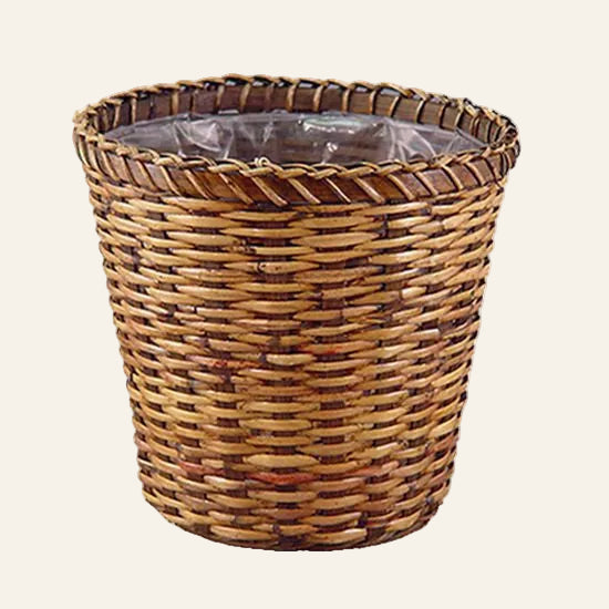 Wicker trash bin with a clear liner on a white background.