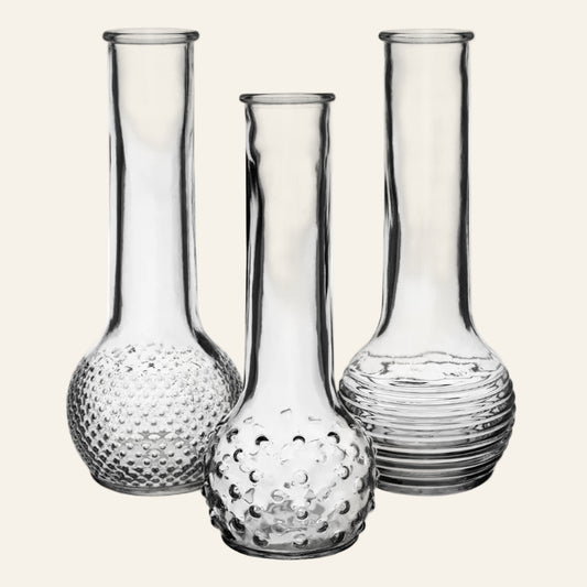 Set of three clear glass vases with textured designs on a white background